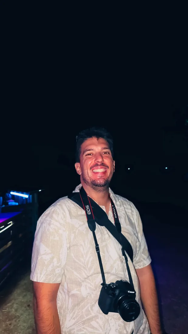 Diogo Carvalheiro com a câmara ao peito durante a cobertura de um evento noturno